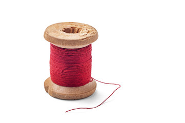Old wooden spool with red threads on a white background