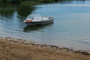 Fototapeta na wymiar Motorboat anchored at the shore of the lake
