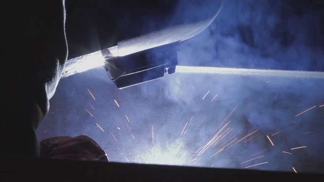 Welder working on an iron plate.