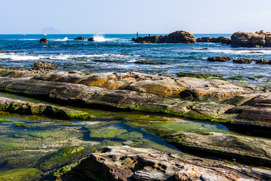 The beautiful coastal reef and sea waves with blue sky in New Taipei, Taiwan