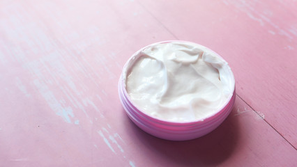 Close up of beauty cream in a pink container 