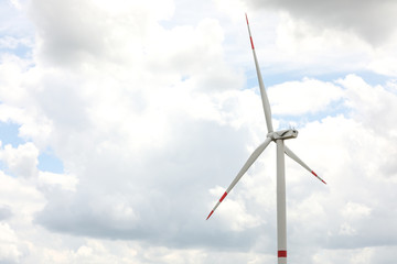 Modern wind turbine against cloudy sky, closeup. Alternative energy source