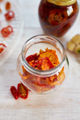Homemade sun dried tomatoes with herbs, garlic in olive oil in a glass jar