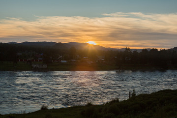 Fototapeta na wymiar Sunset on a choppy river wind early spring landscape