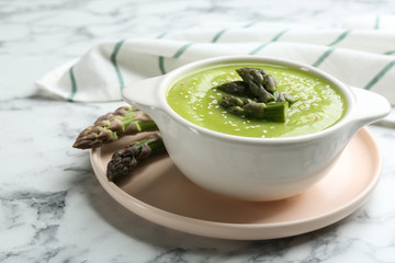 Delicious asparagus soup served on white marble table