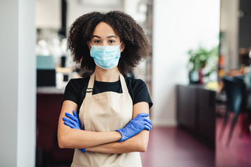 African american girl hairdresser in protective mask posing at salon