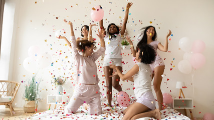Pajama or bachelorette party celebration concept. Five slim active multiethnic women wearing comfy...