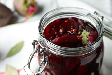 Pickled beets in glass preserving jar on table, closeup