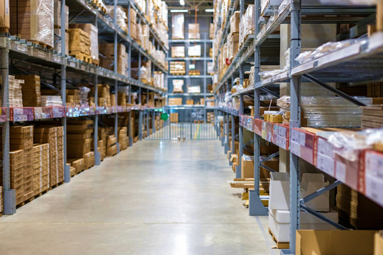 Modern warehouse with goods on collapsible metal shelves. Blurred, focus with shallow depth of field.