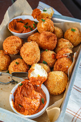Cheese balls with tomato sauce. Fried snack starter meal. Party food