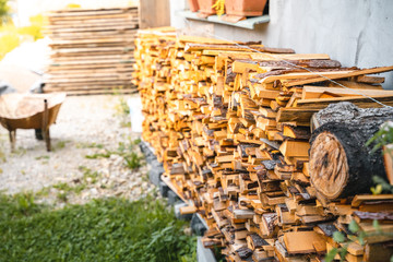 Woodpile of cut Lumber next to house