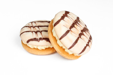 Delicious cream cakes isolated on white background. Sandwich cookies covered with chocolate