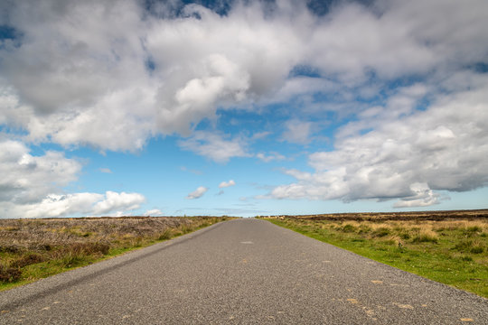 A summer, 3 shot HDR image of a narrow, single track road, across Spaunton Moor in the North York Moors National Park, Yorkshire, England 
