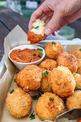 Cheese balls with tomato sauce. Fried snack starter meal. Party food
