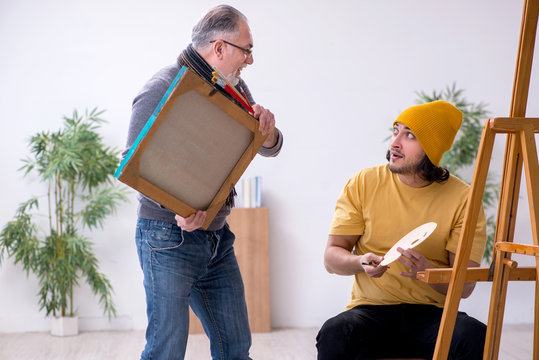 Young man taking lesson from old painter