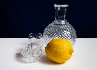 still life with a beautiful glass decanter and fruits on a dark background
