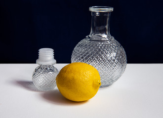 still life with a beautiful glass decanter and fruits on a dark background