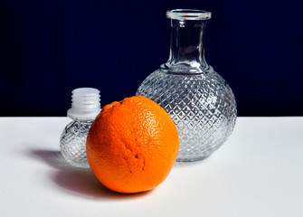 still life with a beautiful glass decanter and orange orange on a dark background