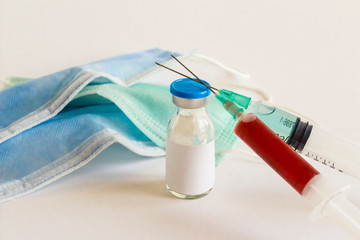 Medicine glass bottle and injectors with medical masks on white background.Conceptual image of...