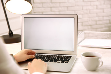 Fototapeta premium Woman working with modern laptop at white table, closeup. space for design