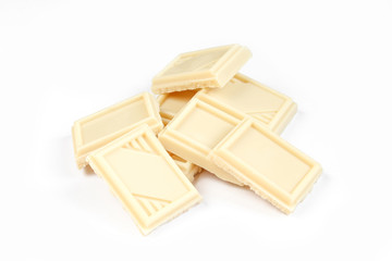 Pieces of white chocolate isolated on white background. Delicious milky sweets