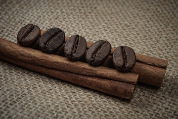 Coffee beans laying on cinnamon bars