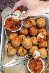 Cheesy balls fried on a baking tray with tomato dip. Close up photo. 