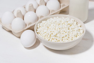 farm dairy products, cottage cheese, milk and eggs on a white background, closeup