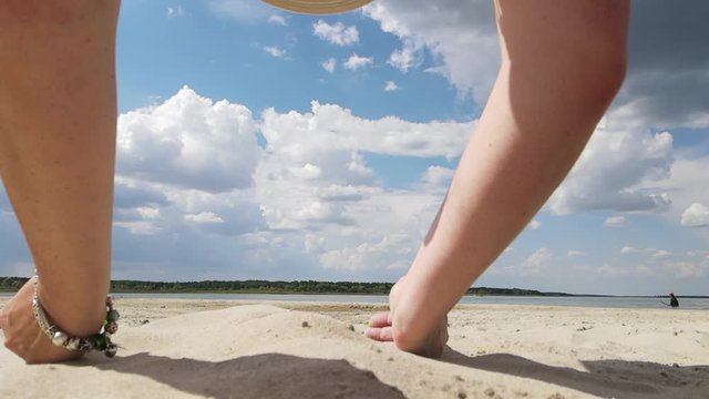 Video, female hands scatter white sand on the beach on a sunny hot day