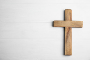 Naklejka na ściany i meble Christian cross on white wooden background, top view with space for text. Religion concept