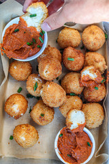 Cheesy balls fried on a baking tray with tomato dip. Close up photo. 