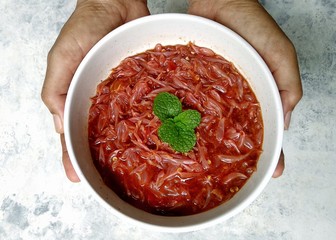 Pomelo salad with hot & spicy shrimp paste sauce on hand over rustic white background