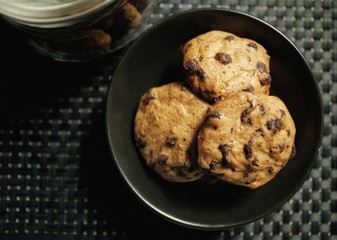 Homemade drop cookies or chocolate chip cookies over dark background 
