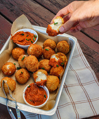 Cheesy balls fried on a baking tray with tomato dip. Close up photo. 