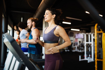 Fototapeta na wymiar Young people running on a treadmill in modern gym