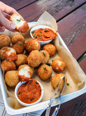 Cheesy balls fried on a baking tray with tomato dip. Close up photo. 