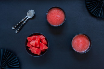 Top view of fresh iced homemade watermelon sorbet, granita, smoothie on black background