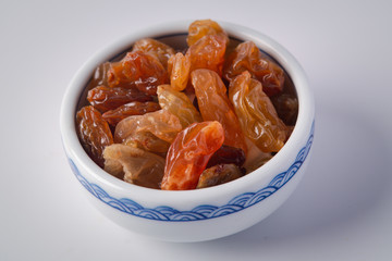 Golden raisins in white ceramic cup