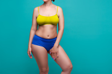 Plus size model in colored underwear on blue background