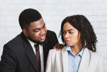 Sexual harassment in office. Male boss touching his disgusted female subordinate at workplace