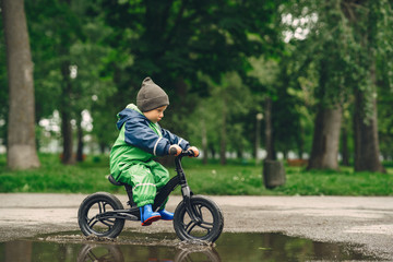 Kids in a puddle. Child having fun outdoors. Boy with bicycle.