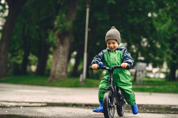 Kids in a puddle. Child having fun outdoors. Boy with bicycle.