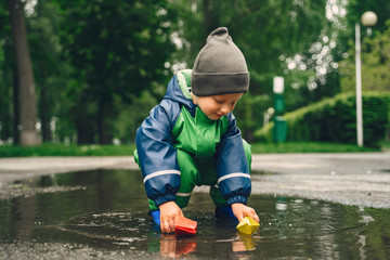 Kids in a puddle. Child having fun outdoors.