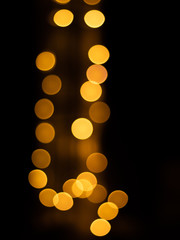 Golden bokhe at night with back black background.