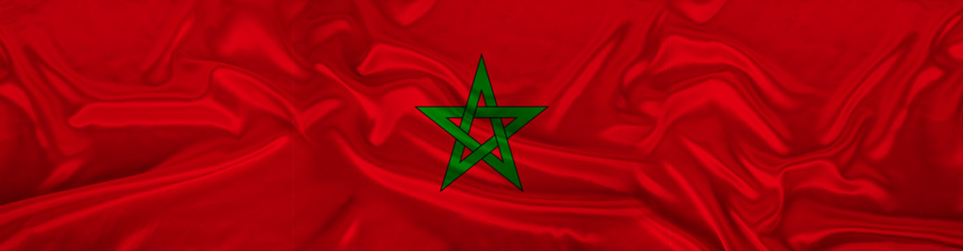 long panorama of the national flag of the state of Morocco with the coat of arms on delicate silk with folds, the concept of tourism, freedom, choice, economy, politics, global world trade