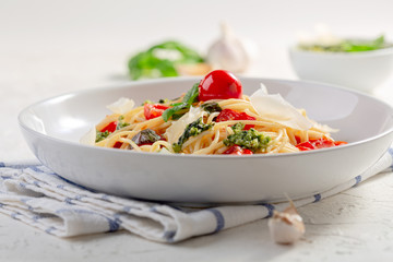 Italian pasta with pesto sauce, fresh basil and cherry tomatoes.