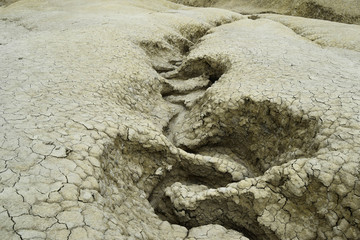 Undulated water canal in dry soil texture. The Berca Mud Volcanoes is a geological and botanical reservation. Small volcano-shaped structures caused by the eruption of mud and natural gases.
