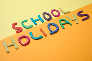 Phrase School Holidays made of modeling clay on color background