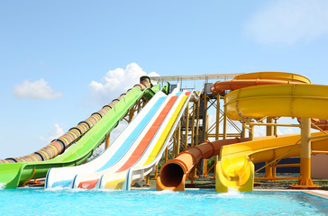 Different colorful slides in water park on sunny day