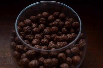 Breakfast. Chocolate balls from cocoa in a beautiful transparent glass on a dark background.